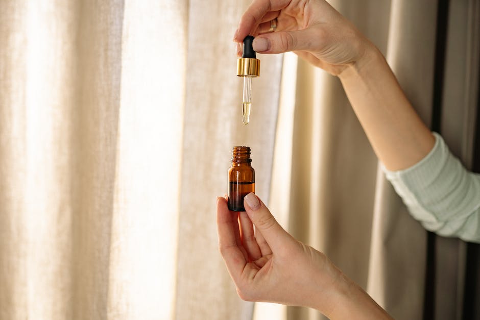 A Person Holding Amber Glass Dropper Bottle with Oil